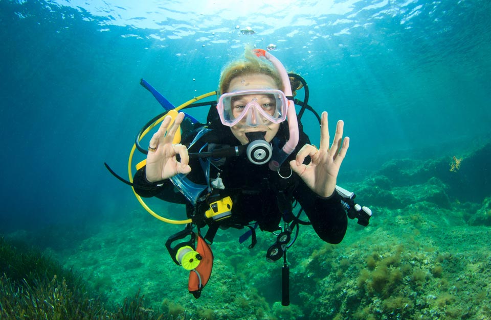 fully equipped scuba diver signaling ok